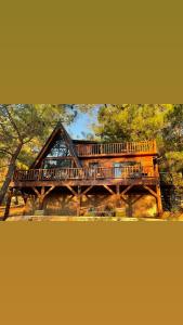 a large wooden deck on a house in the woods at Panurla Wooden House havuz & sauna kırmızı in Urla