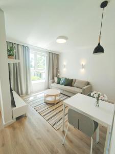 a living room with a couch and a table at M&K - Vyspa Apartamenty in Gdańsk