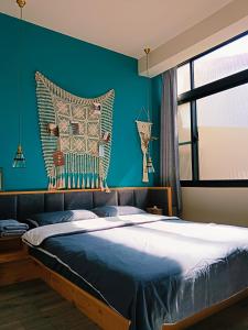 a bedroom with a large bed with a blue wall at 三田包棟旅宿MITA Inn in Tainan