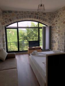 a bedroom with a large bed and a large window at Bujtina Vrenezi in Peshkopi