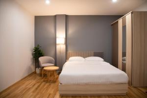 a bedroom with a bed and a table and a chair at J & L Residence and Spa in Ban Khlong Khwang Klang
