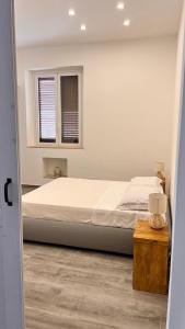 Un dormitorio con una cama grande y una ventana en Dimora Donna Vitalia Apartments, en Erice