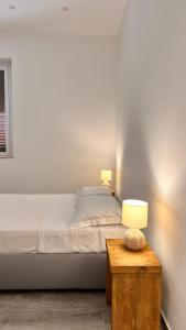 a bedroom with a bed and a table with a lamp at Dimora Donna Vitalia Apartments in Erice