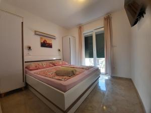 1 dormitorio con cama con sábanas rosas y ventana en San Lorenzo, en Lopar