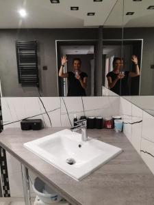 Ein Mann, der ein Foto in einem Badezimmerspiegel macht. in der Unterkunft Pokoje u Orła w Szklarskiej Porębie in Szklarska Poręba