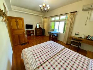 志學村的住宿－後山歲月民宿 ，一间卧室配有一张床、一张桌子和一个窗户。