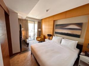 um quarto de hotel com uma cama grande e uma cadeira em Fashion Avenue Dubai Mall no Dubai