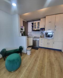 a kitchen with white cabinets and a green ottoman at Luxury Penthouse Residence Kasandra in Jesenice