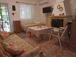LENA'S SWEET HOME في أرتيميدا: غرفة معيشة مع أريكة وطاولة ومدفأة