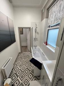 a bathroom with a white tub and a sink at 2 Bed ground floor apartment, sleeps 4 with free parking in Harrogate