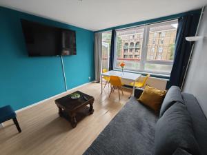 a living room with a couch and a table at 2 BEDROOM FLAT NEXT TO ARSENAL STADIUM - HIGHBURY in London