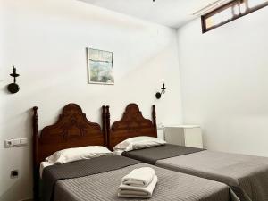 two beds in a white room with towels on them at Easy Nerja Bronce in Nerja
