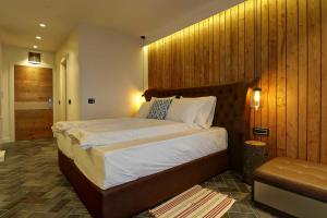 Surdulica的住宿－Vlasinsko jezero VILA BEST，一间卧室设有一张带木墙的大床