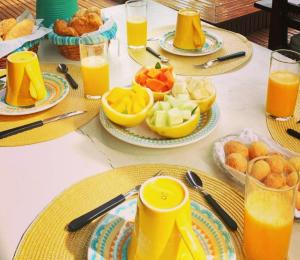 stół z talerzami jedzenia i szklanki soku pomarańczowego w obiekcie KazaBrasil w mieście Icaraí