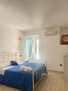 1 dormitorio con cama con sábanas azules y ventana en Corte San Martino, en Mesagne