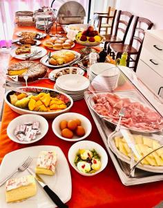 uma mesa longa cheia de comida numa mesa vermelha em Hotel Le Ali em Rimini