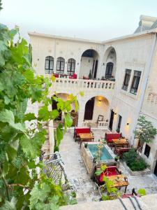 un patio de un edificio con piscina y mesas en karagül otel en Sanlıurfa