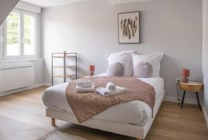 Un dormitorio blanco con una cama grande con zapatos. en Nouveau - L'indiana - Jardin partagé, barbecue en Diemeringen