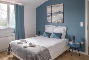 um quarto com paredes azuis e uma cama com toalhas em Nouveau - L'océan - Jardin partagé, barbecue em Diemeringen