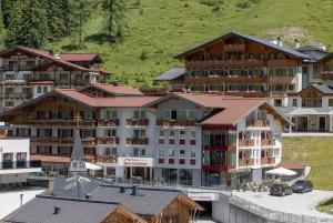 een groep gebouwen in een stad met een berg bij Hotel Sportalmmm, Hoch-Genuss in Zauchensee