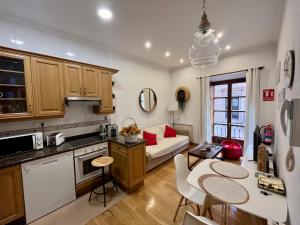 a kitchen and living room with a couch and a table at MyHouseSpain - Acogedor apartamento plaza mayor Gijón 1 in Gijón