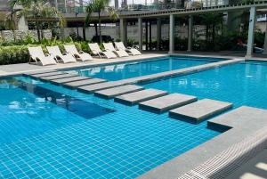 a large swimming pool with lounge chairs in a building at Gravins616 Condo BCD in Bacolod