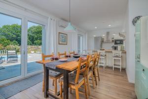 kuchnia i jadalnia z drewnianym stołem i krzesłami w obiekcie House Tonica with pool w mieście Malinska