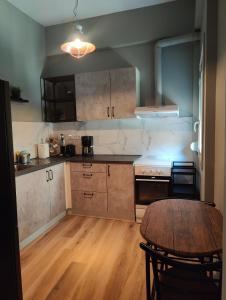 a kitchen with a wooden table and a wooden floor at Deluxe Center Apartment - Preveza in Preveza