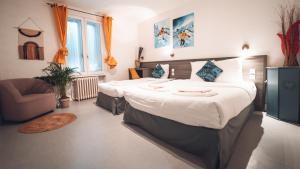 1 dormitorio con 1 cama grande y 1 silla en Logis Hôtel Restaurant Vuillot, en Cuiseaux