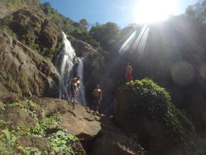 a group of people standing in front of a waterfall at Hotel Perico Azul & Surf Camp in Jacó
