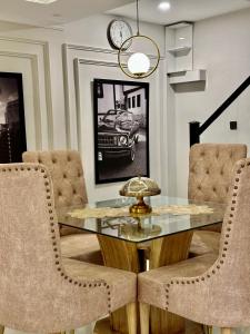 une salle à manger avec une table et des chaises en verre dans l'établissement Emeralds Villa Islamabad, à Islamabad