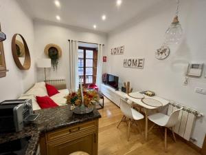 a kitchen and living room with a table and a couch at MyHouseSpain - Acogedor apartamento plaza mayor Gijón 1 in Gijón