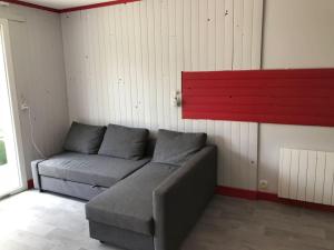 um sofá num quarto com uma parede vermelha em Gîte du Port Charbonnier 