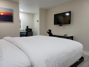 a bedroom with a white bed and a flat screen tv at Quality Inn Victorville I-15 in Victorville