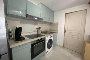 a kitchen with a sink and a washing machine at Small villa 40m with terrace near the beach in Fleury