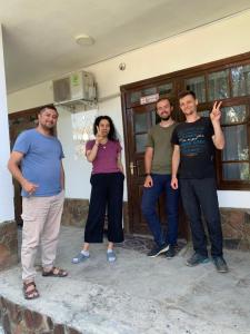 a group of people standing in front of a house at Salom Hostel in Panjakent