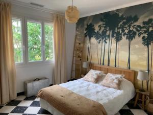 1 dormitorio con 1 cama con palmeras en la pared en VACANCES en Le Grau-dʼAgde