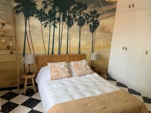 1 dormitorio con 1 cama con palmeras en la pared en VACANCES en Le Grau-dʼAgde
