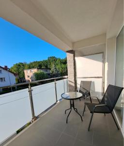 een balkon met een tafel en stoelen en uitzicht bij Al-Dom Apartamenty, Apartament SUN w Welle z dostępem do sauny i jacuzzi in Grzybowo