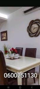 einen Esstisch mit Stühlen und eine Uhr an der Wand in der Unterkunft Silver city 2 in Jagodina