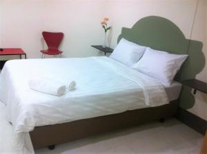 een slaapkamer met een groot bed met een groen hoofdeinde bij City Inn Udonthani in Udon Thani