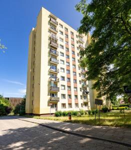 a tall apartment building with a tree in front of it at ApartamentyGdanskEU - Mieszkanie Mewa in Sopot