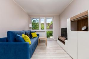 um sofá azul com almofadas amarelas numa sala de estar em ApartamentyGdanskEU - Mieszkanie Mewa em Sopot