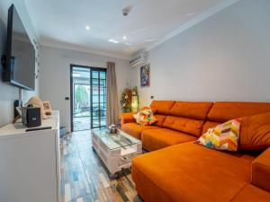 a living room with an orange couch and a table at Balcón de Costanera in Santa Cruz de Tenerife