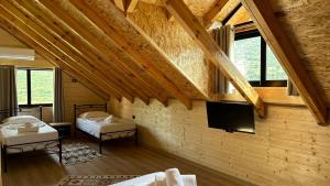 a room with two beds and a flat screen tv at Hotel Nemercka & Outdoor Sports Center in Përmet