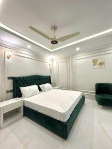 - une chambre avec un lit et un ventilateur de plafond dans l'établissement Emeralds Villa Islamabad, à Islamabad