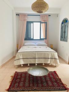a bedroom with a bed with a large window at Dar Narjis in Asilah