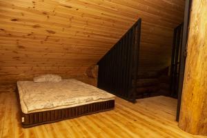 a bedroom with a bed in a wooden room at Pirtis pas Astą 