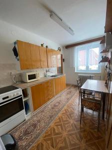 a kitchen with wooden cabinets and a table with a dining room at Domeček Pod horami in Raškovice