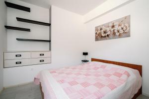 1 dormitorio con 1 cama y una pintura en la pared en Charming little apartment, en Čilipi